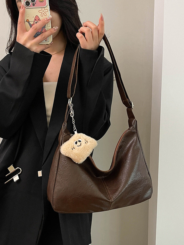 Women's slouchy underarm shoulder bag in brown faux leather with bag charm